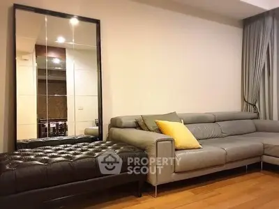 Stylish living room with modern gray sofa and large mirror