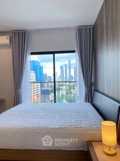 Modern bedroom with city view, large window, and stylish decor.