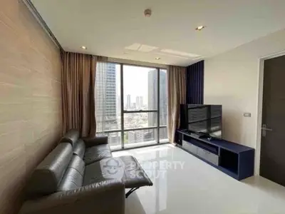 Modern living room with city view, sleek leather sofa, and large TV in high-rise apartment.