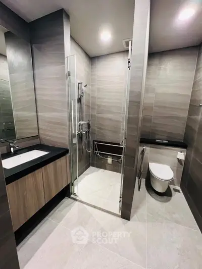Modern bathroom with sleek design, glass shower, and elegant fixtures in a contemporary apartment.