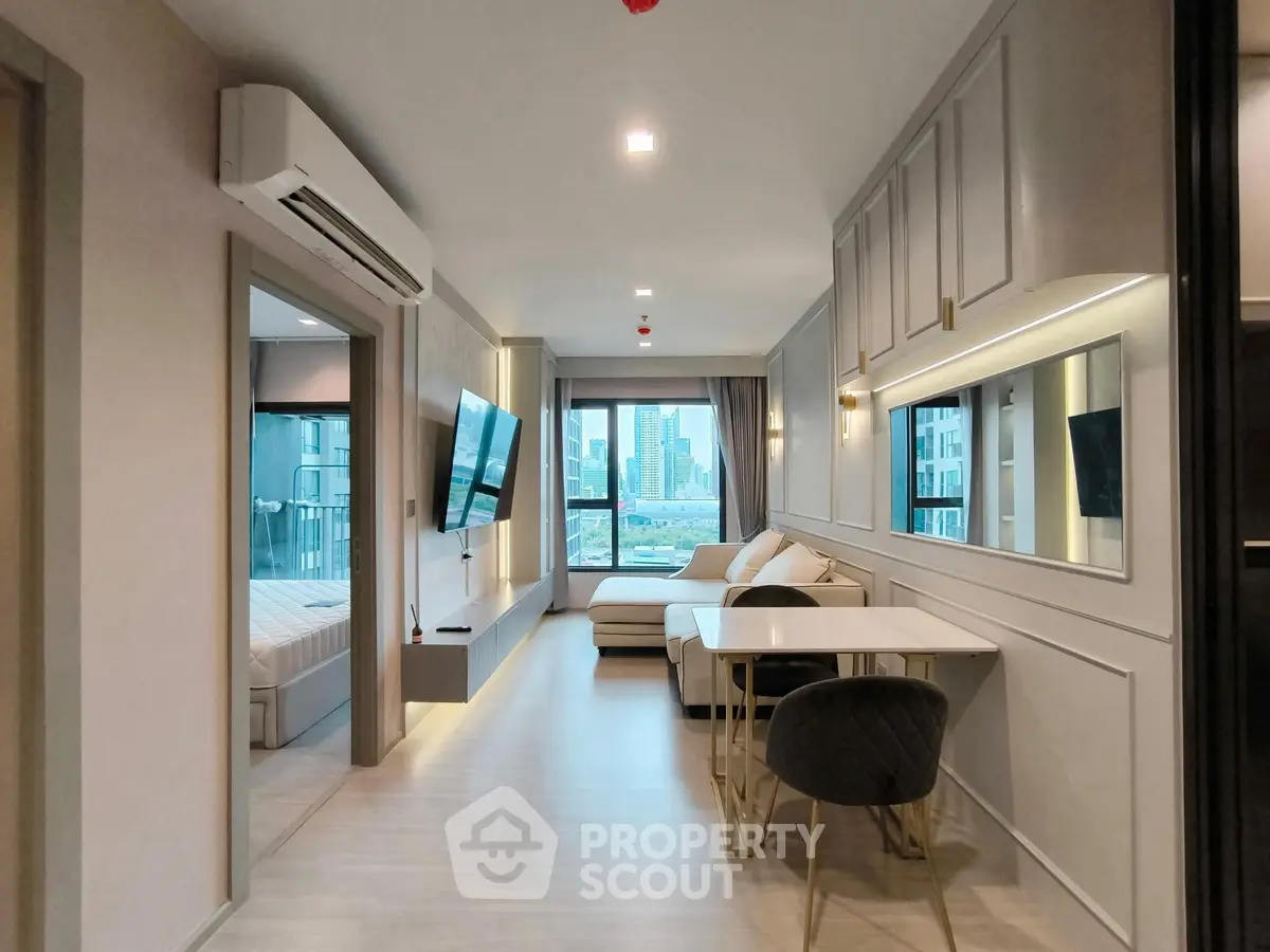 Modern open-plan living room with stylish decor and city view, featuring a cozy dining area and wall-mounted TV.