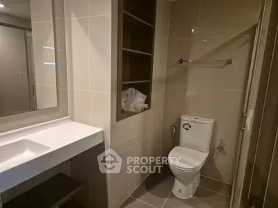 Modern bathroom with sleek design and built-in storage shelves.