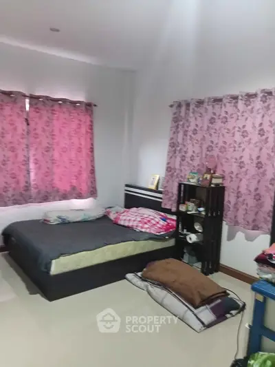 Cozy bedroom with floral curtains and modern decor, perfect for a comfortable living experience.
