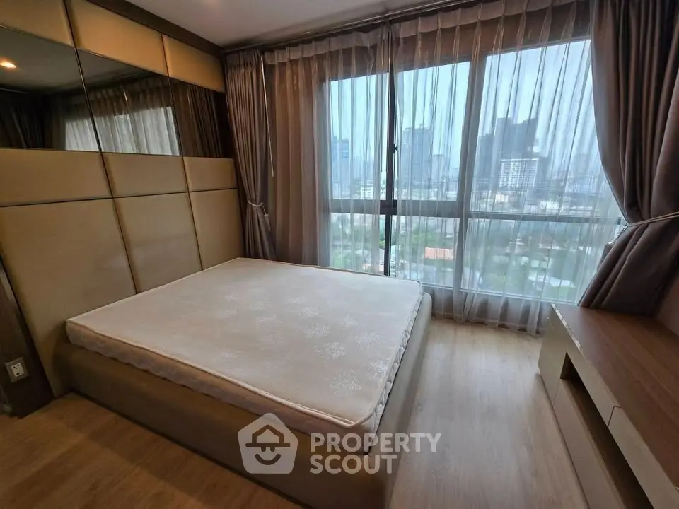 Spacious bedroom with city view and modern decor in high-rise apartment