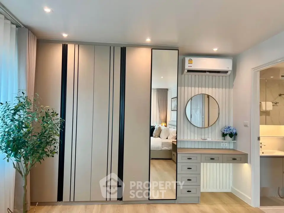 Modern bedroom with sleek wardrobe and vanity, featuring elegant decor and soft lighting.