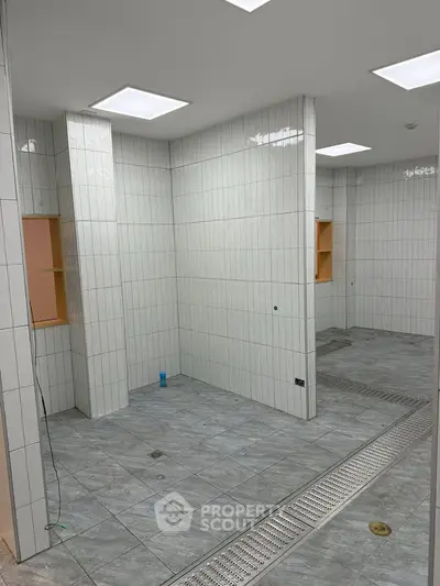 Spacious tiled bathroom with modern design and ample lighting