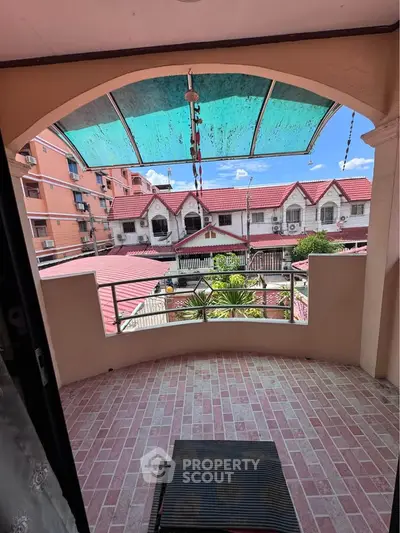 Charming balcony with tiled floor and scenic view of neighboring rooftops, perfect for relaxation.