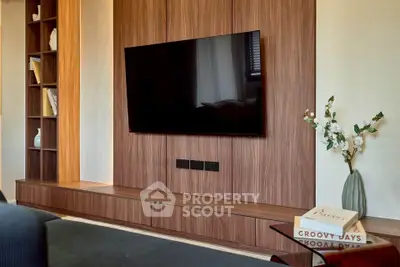 Modern living room with sleek wooden paneling and mounted TV, perfect for entertainment.