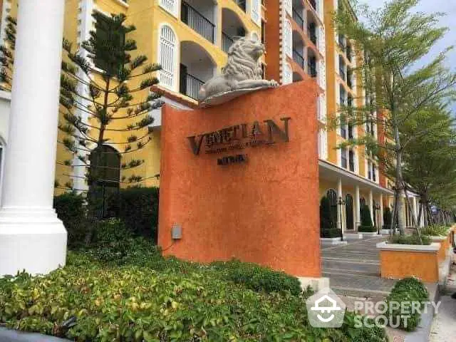 Elegant Venetian-style building entrance with lush greenery and architectural details.