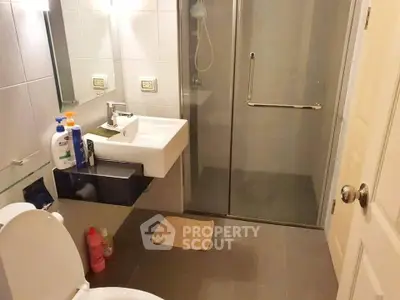 Modern bathroom with glass shower and sleek fixtures in a contemporary home.