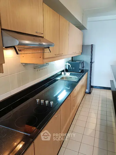 Modern kitchen with sleek appliances and wooden cabinetry in a spacious layout.