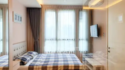 Modern bedroom with stylish decor and large windows offering natural light