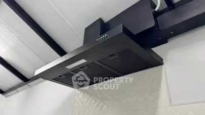 Modern kitchen with sleek black range hood and stylish backsplash