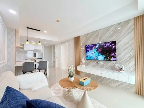 Modern living room with stylish decor, open kitchen layout, and wall-mounted TV for a contemporary lifestyle.