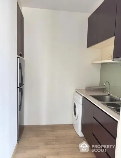 Modern compact kitchen with sleek cabinets and washing machine