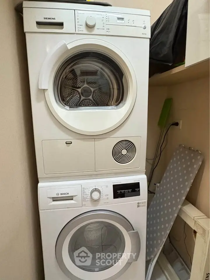 Modern laundry area with stacked Siemens and Bosch washer and dryer in a compact space.