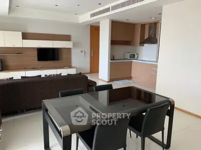 Modern open-plan living room and kitchen with sleek furniture and appliances.