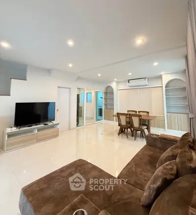 Spacious modern living room with cozy brown sofa and sleek TV setup