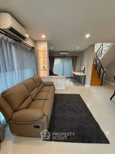 Spacious modern living room with stylish furniture and elegant staircase