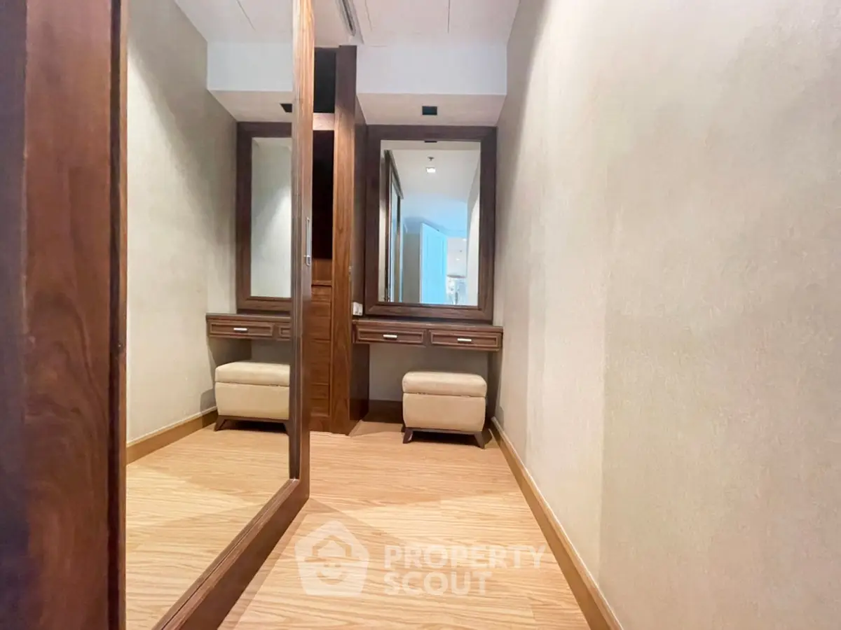 Spacious walk-in closet with elegant wooden finishes and ample storage space.