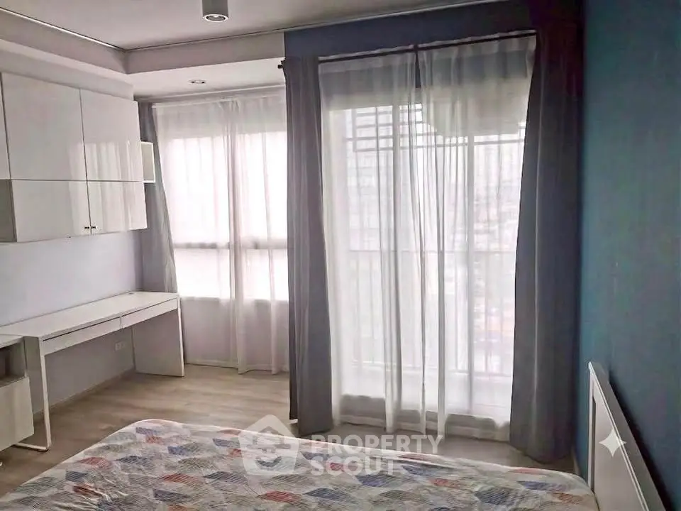 Bright and airy bedroom with large windows and modern furnishings in a stylish apartment.