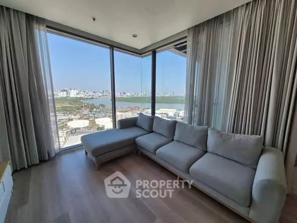 Spacious living room with panoramic city view and modern gray sofa.