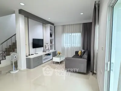 Modern living room with sleek design, featuring a cozy sofa, TV unit, and elegant decor in a bright, airy space.