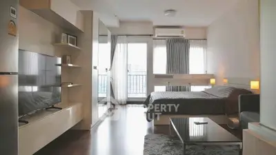 Modern studio apartment with sleek design and large windows offering city views.