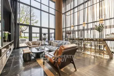 Luxurious modern living room with floor-to-ceiling windows and elegant furnishings, offering a stunning view.