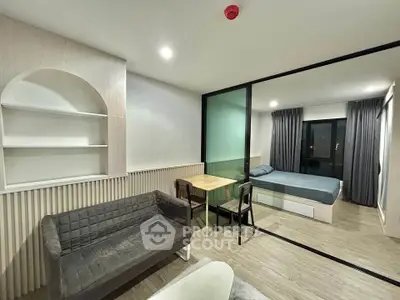 Modern studio apartment with glass partition, cozy living area, and stylish bedroom.