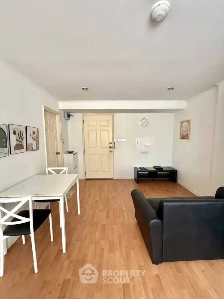 Spacious living room with modern furniture and wooden flooring in a cozy apartment.