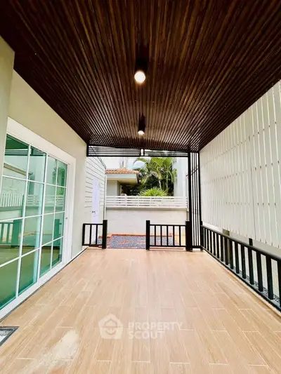 Stylish covered patio with wooden ceiling and modern design elements.