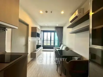 Modern living room with sleek furniture and large window offering a scenic view.