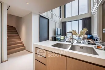 Luxurious modern kitchen with open layout and stunning view, featuring sleek cabinetry and elegant dining setup.