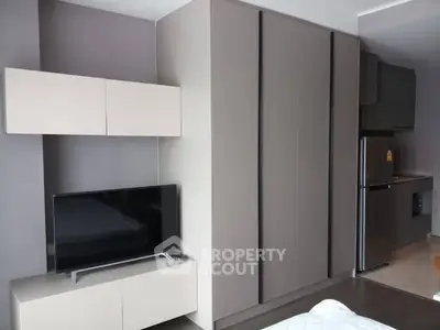 Modern apartment interior with sleek cabinetry and TV setup