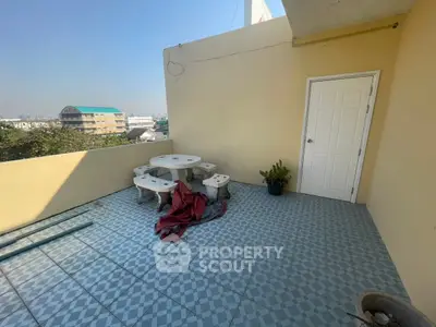 Spacious balcony with seating and city view, perfect for relaxation.