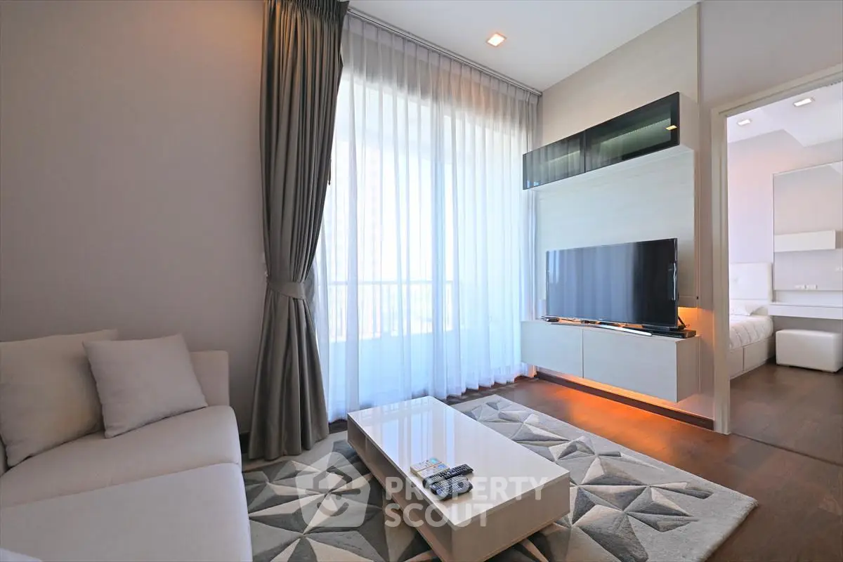 Modern living room with stylish decor and natural light, featuring a sleek TV setup and cozy seating area.