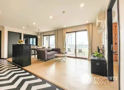 Spacious living room with modern decor and large windows offering stunning city views