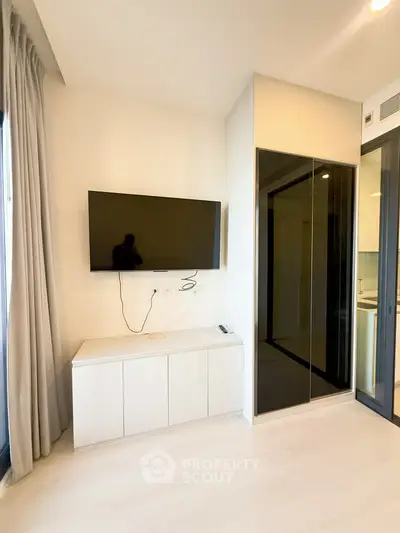 Modern living room with wall-mounted TV and sleek storage cabinet