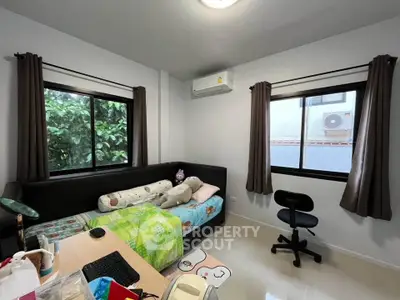 Cozy bedroom with modern furnishings and natural light, perfect for relaxation and productivity.