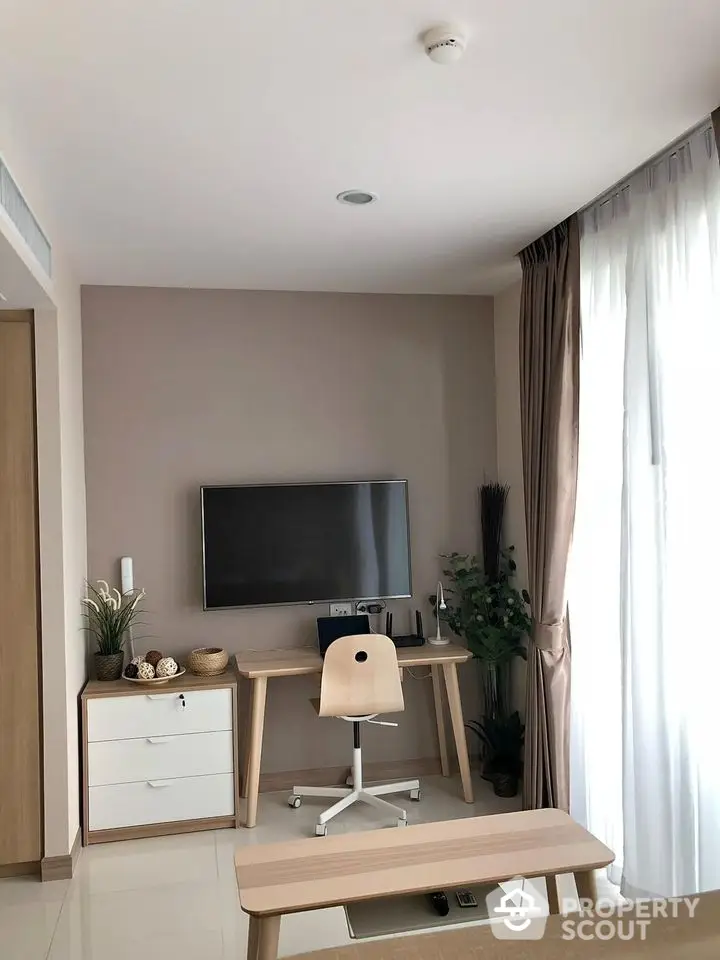 Modern study room with sleek desk, chair, and wall-mounted TV in bright apartment