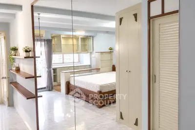 Spacious bedroom with modern decor and large windows offering natural light.