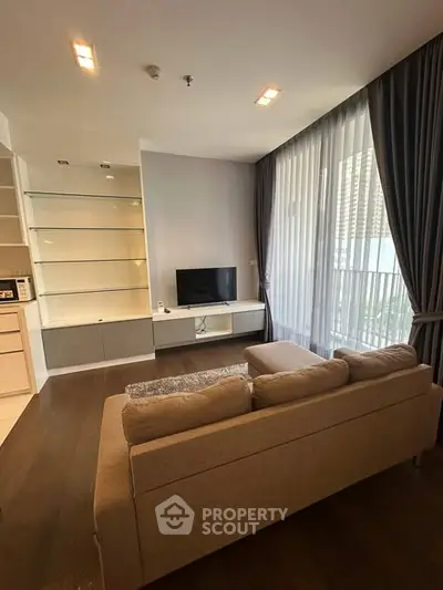 Modern living room with large windows and cozy sofa in a high-rise apartment.