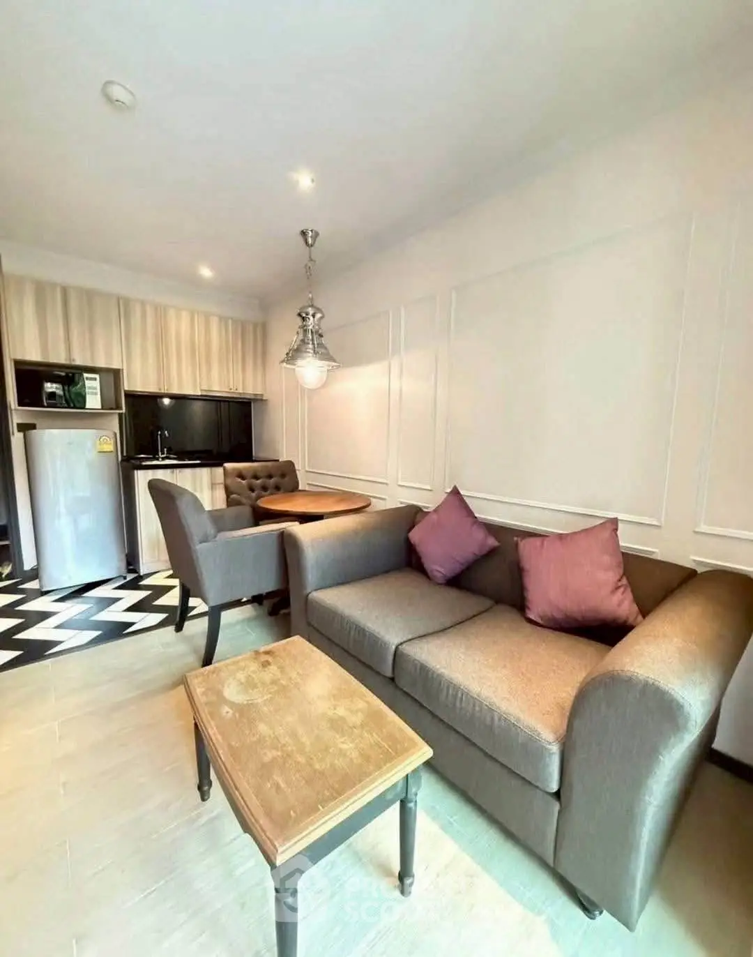 Charming living room with cozy sofa and modern kitchen in open layout apartment.
