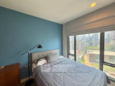 Cozy bedroom with city view, featuring a stylish bed and modern decor, perfect for urban living.