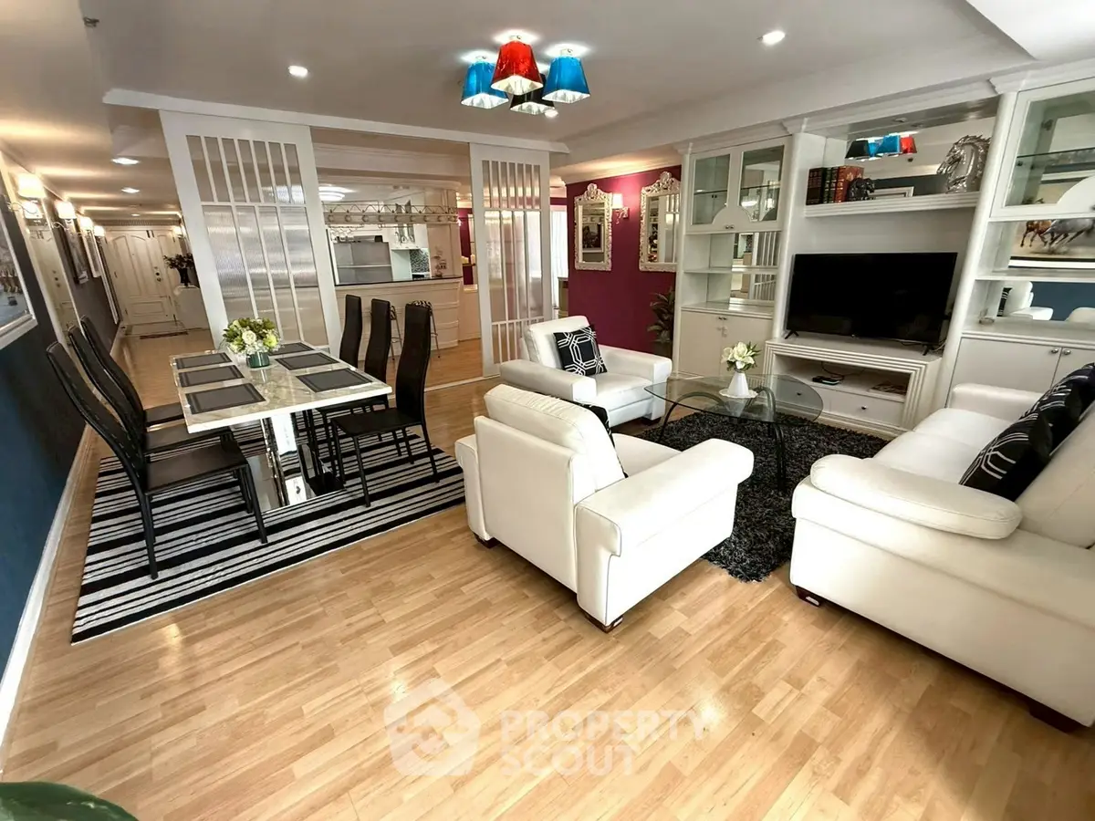 Spacious living room with elegant decor and open layout, featuring white sofas and a stylish dining area.