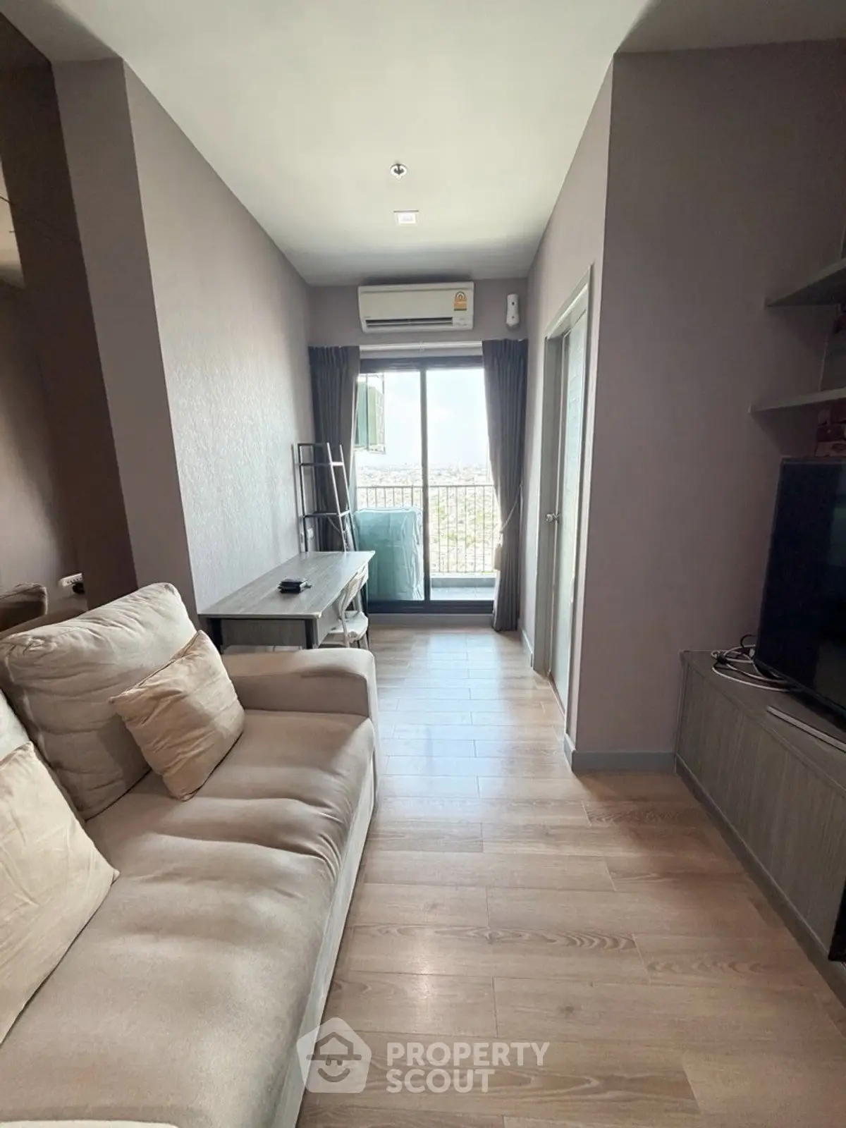 Cozy living room with modern decor and balcony view in a stylish apartment.