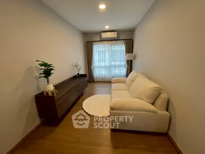 Cozy living room with elegant sofa and wooden flooring, perfect for relaxation and comfort.