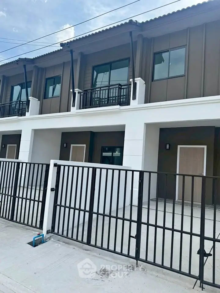 Modern townhouse exterior with gated entrance and contemporary design.