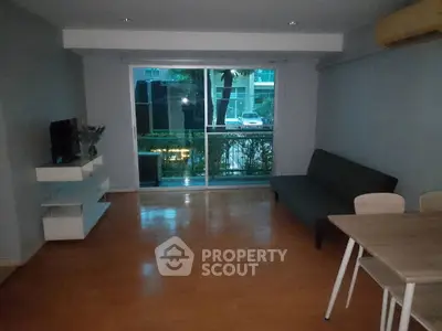 Spacious living room with modern decor and large window view.